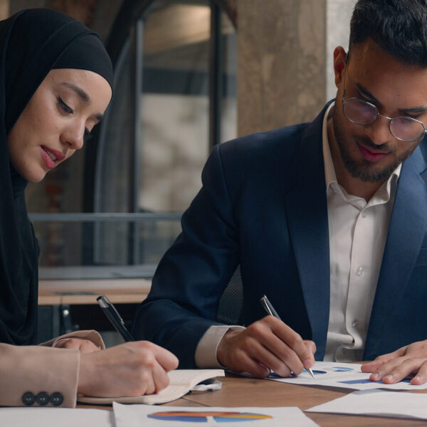 Two business colleagues co-workers talk discuss corporate work at office cafe multiracial male female employees Indian man muslim woman in hijab diverse businesswoman businessman write tasks laptop Two business colleagues co-workers talk discuss corporate work at office cafe multiracial male female employees Indian man muslim woman in hijab diverse businesswoman businessman write tasks laptop. High quality 4k footage